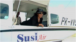 Ibu Menteri, Susi Pudjiastuti, berpose dari balik jendela pesawatnya.