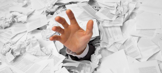 Hand reaches out from crumpled papers